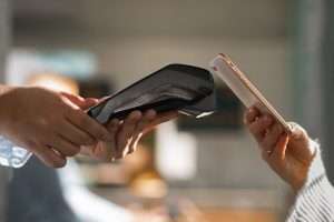A person using a phone to make a contactless payment.