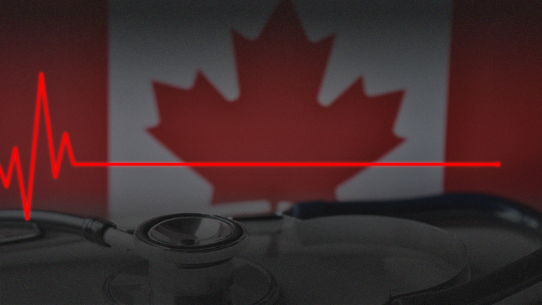 Heart monitor flatline in front of Canadian flag.