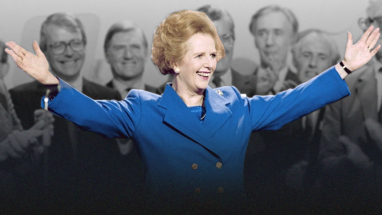 Margaret Thatcher standing triumphantly with her arms out.