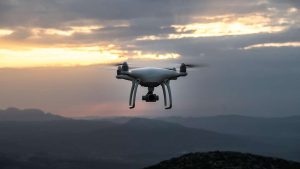 Drone in the sky with landscape in the background.